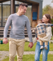 A mother, father, and child hold hands in front of their home.