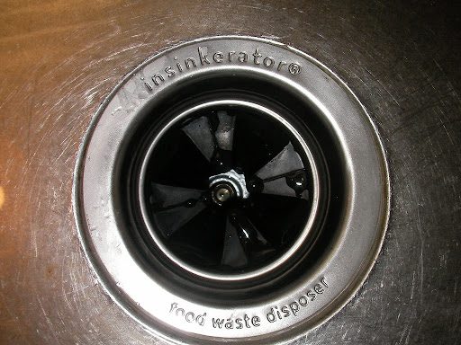A top view of a garbage disposal in a sink drain.