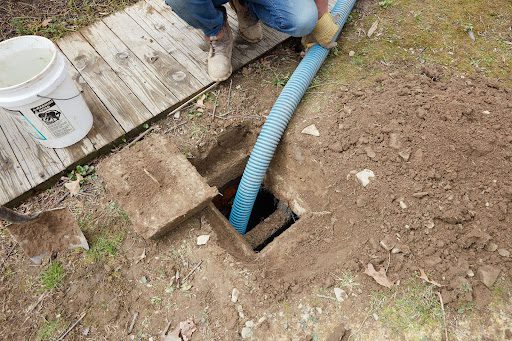 A septic system being drained with a large hose.