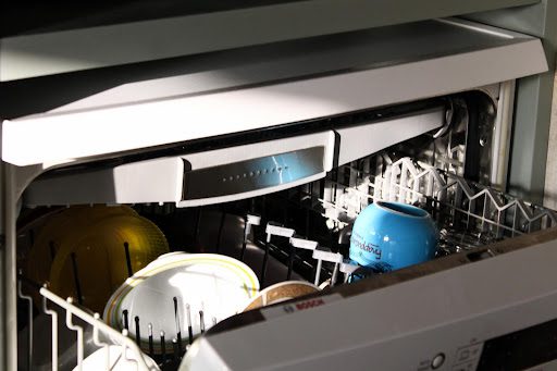 A dishwasher loaded with plates and cups.