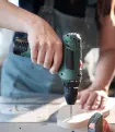 A contractor unscrews the back of an appliance.